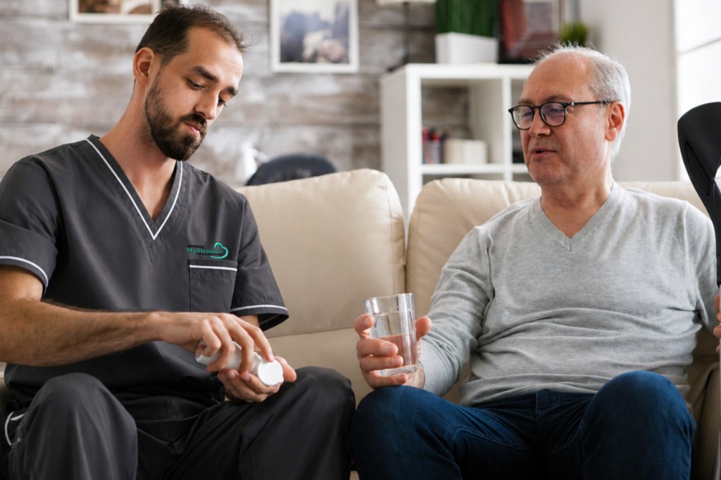 Homecare provider assisting a client with medication at home